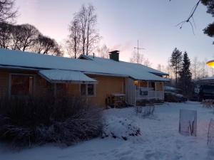 a house with snow on the roof of it at Dome Backpackers hostel Ounasvaara in Rovaniemi