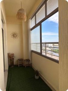 a room with a large window and a green carpet at Vue Mer Exeptionnelle à Essaouira in Essaouira
