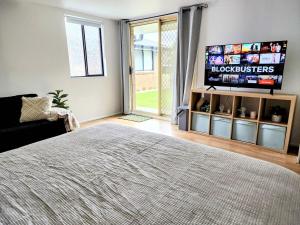 a bedroom with a bed and a flat screen tv at Quiet Peaceful Getaway with private backyard in Penrith