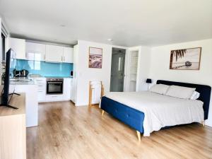 a bedroom with a large bed and a kitchen at Quiet Peaceful Getaway with private backyard in Penrith