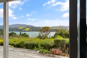 een uitzicht op een meer vanaf de veranda van een huis bij Mangonui Ridge Retreat in Mangonui