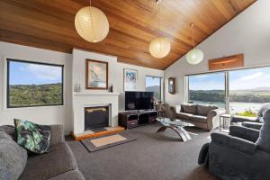 een woonkamer met een bank en een open haard bij Mangonui Ridge Retreat in Mangonui
