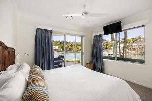 ein Schlafzimmer mit einem großen Bett und einem großen Fenster in der Unterkunft 21 Wesley Court Noosa Sound in Noosa Heads + 37 Fotos
