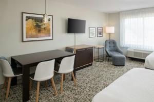 a hotel room with a bed and a desk and chairs at TownePlace Suites by Marriott Slidell in Slidell