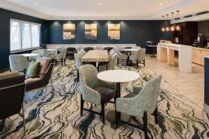 a lobby with tables and chairs and a bar at TownePlace Suites by Marriott Slidell in Slidell
