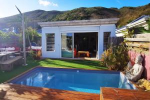 a backyard with a swimming pool and a house at Un ptit coin de bonheur in Cul de Sac