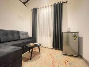 a living room with a couch and a refrigerator at Harbor Moon in Hiriketiya