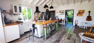 a kitchen with white cabinets and a wooden counter top at Un ptit coin de bonheur in Cul de Sac