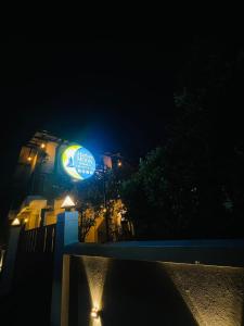 a building with a blue sign on it at night at Harbor Moon in Hiriketiya