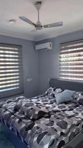 a bedroom with a black and white bed with windows at Cozy 2-bedrooms in Lakeside Estate Accra in Apenkwa +50 photos
