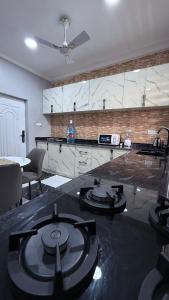 a living room with a kitchen with a stove at Cozy 2-bedrooms in Lakeside Estate Accra in Apenkwa