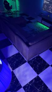 a room with a bed with purple and green lights at Cozy 2-bedrooms in Lakeside Estate Accra in Apenkwa