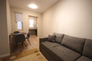een woonkamer met een bank en een tafel bij Jera Apartment 1 in Tirana