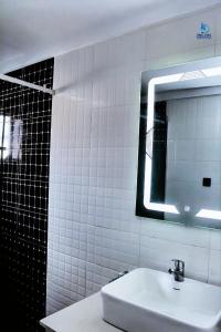 a white bathroom with a sink and a mirror at Dreamz Hotel and Suites in Ogbomoso