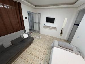 ein Wohnzimmer mit Sofa und Fernseher in der Unterkunft Casa em Angra dos Reis, no parque mambucaba in Angra dos Reis