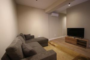 ein Wohnzimmer mit Couch und Flachbildfernseher in der Unterkunft Jera Apartment 1 in Tirana