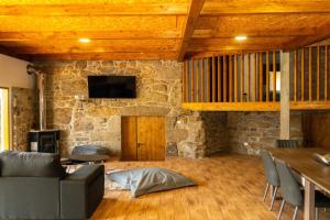 a living room with a couch and a stone wall at Quinta dos Castanheiros in Oliveira de Frades