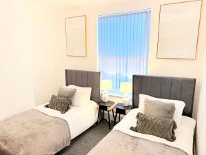 a bedroom with two beds and a window at 4 bedrooms 8 beds Wi-FI smart tv games room in Hull
