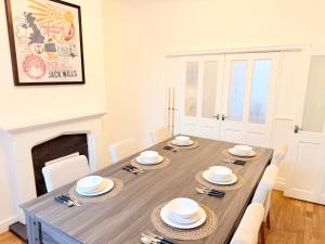 a dining room with a table with chairs and a fireplace at 4 bedrooms 8 beds Wi-FI smart tv games room in Hull +9 photos