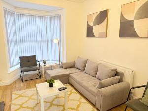 a living room with a couch and a table at 4 bedrooms 8 beds Wi-FI smart tv games room in Hull