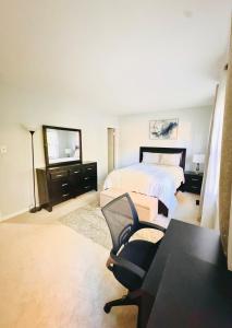 Un dormitorio con una cama, una silla y un espejo. en Charming 4BR 4BA Townhouse In Annandale, VA, en Annandale 35 fotos más