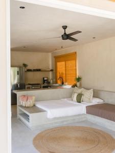a bedroom with two beds and a kitchen at Proyecto Palmita in El Pescadero
