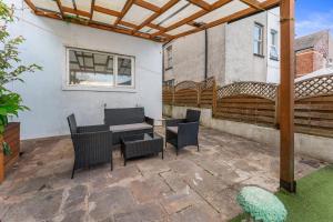 a patio with a table and chairs and a fence at The Royal Stay at Queens Hill Sleeps 10 in Newport