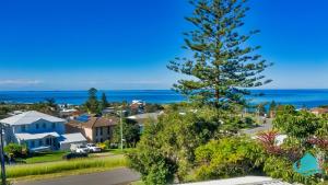 Una vista de un suburbio con un árbol de Navidad. en Cove on Caves - Minutes from the Beach, en Caves Beach