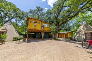 a house on a tree with a building at la Pluma Retreat in Fourth Crossing