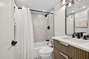 a bathroom with a toilet and a tub and a sink at Mama's Little House in Virginia Beach +35 photos