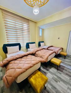 a bedroom with two beds and a chandelier at Gazisehir gold hotel in Şahinbey