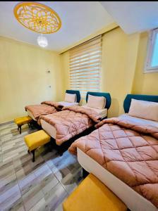 a bedroom with two beds and a chandelier at Gazisehir gold hotel in Şahinbey