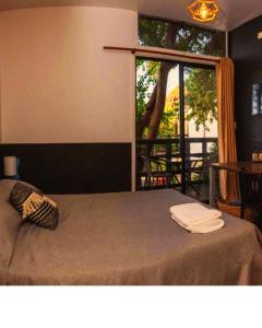 a bedroom with a bed with a large window at Abanico Suites con Kitchenette y Parking in Maitencillo