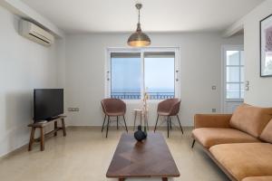 uma sala de estar com um sofá e uma TV em Trithea Villa em Vlachata