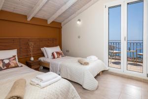 a bedroom with two beds and a balcony at Trithea Villa in Vlachata