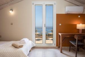 um quarto com uma cama, uma escrivaninha e uma varanda em Trithea Villa em Vlachata mais 22 fotografias