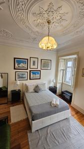 a bedroom with a large bed and a chandelier at Costa do Castelo Lisbon Accomodation in Lisbon