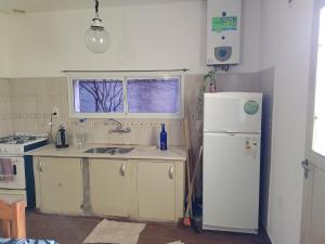 Una cocina con un refrigerador blanco y un fregadero. en Silvia, en Marcos Juárez
