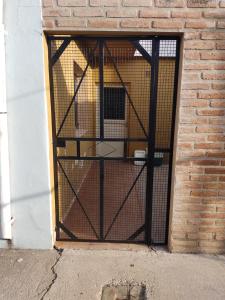 una puerta en una pared de ladrillo con jaulas para animales en Silvia, en Marcos Juárez