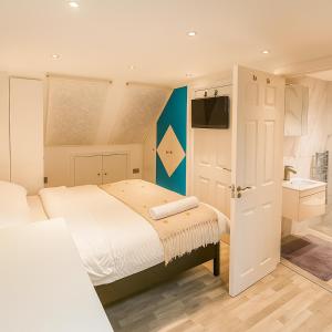 a bedroom with a bed and a tv and a bathroom at Bright Loft Room Near Wembley Stadium in The Hyde