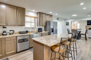 a kitchen with wooden cabinets and a island with bar stools at Hot Tub and Lake Access Spacious Tobyhanna Home in Tobyhanna