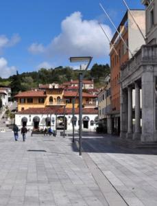 a city street with buildings and a street sign at Ani's home in Monfalcone