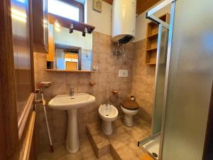 Un baño pequeño con lavabo e inodoro. en Mansarda Veronza, en Castello di Fiemme 12 fotos más