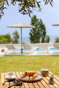 une table avec une assiette de pain et une tasse de café dans l'établissement Villa Santa Maria with private pool and sea view, à Afantou