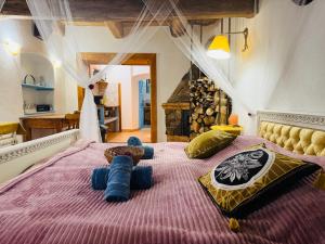 ein Schlafzimmer mit einem lila Bett mit Kissen darauf in der Unterkunft Zázrak Wellness in Banská Štiavnica