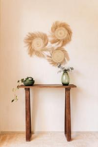 a wooden table with a vase on a wall at Izkina casa hotel centro cozumel in Cozumel