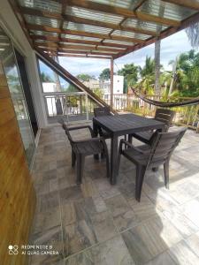 a patio with a table and chairs and a hammock at cabañas Brisas y Perla by AMAUNA in Moñitos