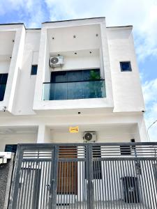 a white house with a gate in front of it at DipNik Residence in Lagos