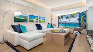 a living room with a white couch and blue pillows at ❤PiH❤ Hapuna Beachfront Bliss Beachfront Steps From Ocean B29 in Hapuna Beach