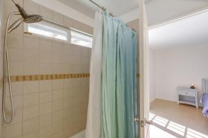 a bathroom with a shower with a blue shower curtain at Family Home, 7 Mi to Joshua Tree National Park! in Twentynine Palms +20 photos